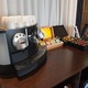 Nespresso machine and refrigerator filled with water and soft drinks